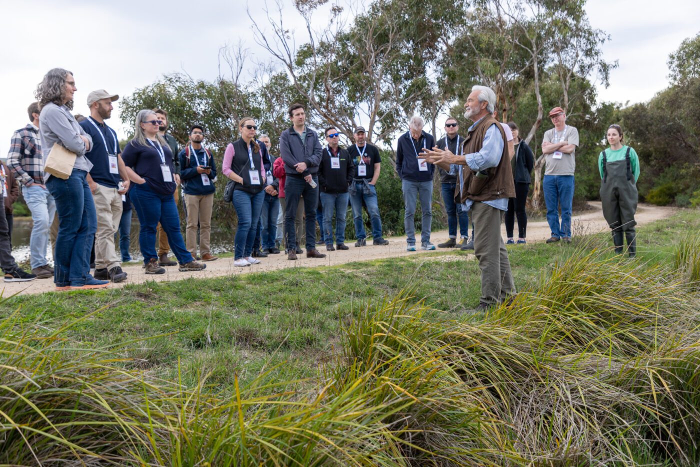 Group standing outside listening to a man talking