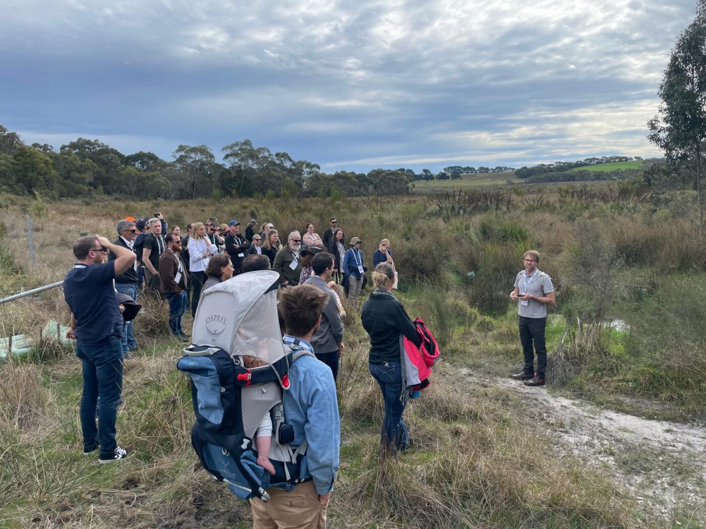 Group standing listening to man talk with native swamp lands in the surrounds