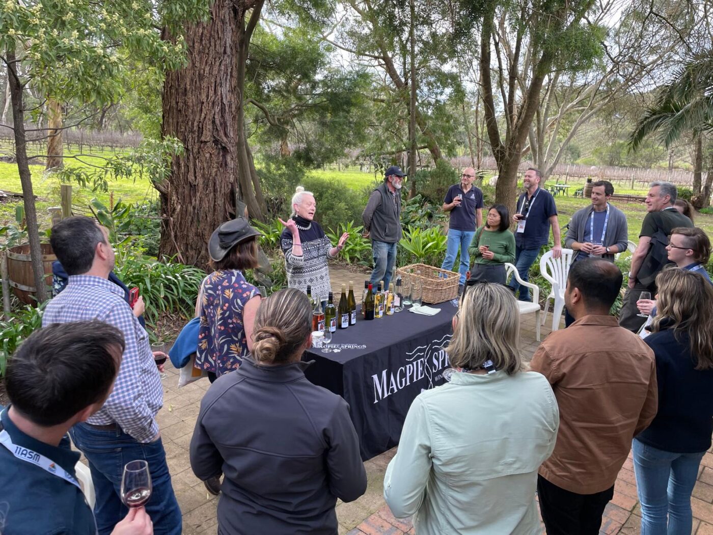 Woman talking to group in front of wine tasting table